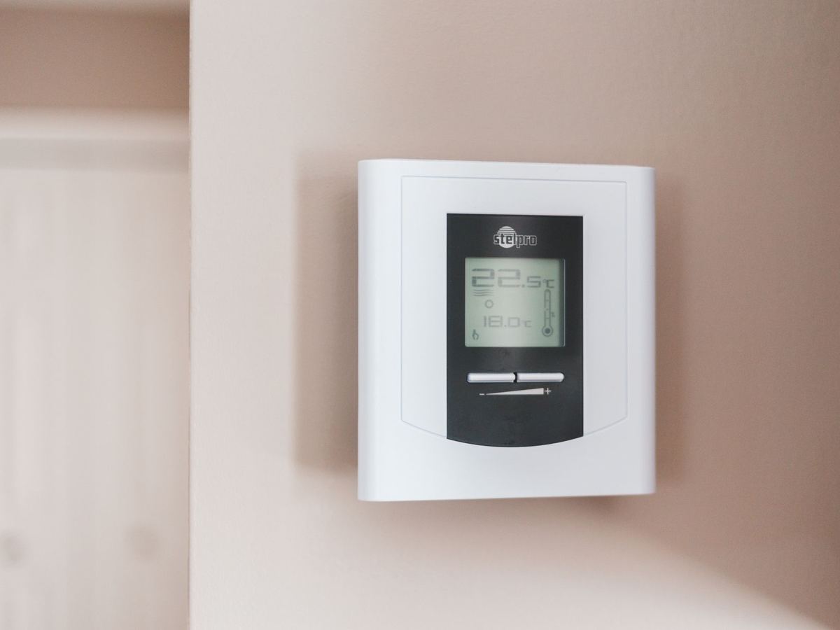 Thermostat programmable fixé au mur d'un logement